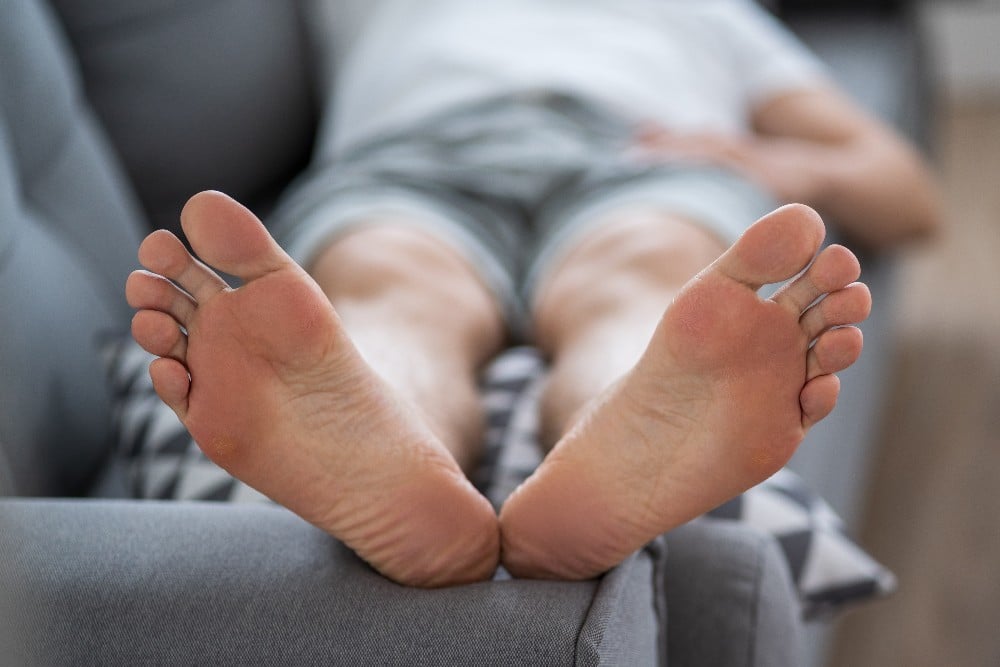 Man resting feet to treat heel pain.